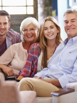 Family With Adult Children Relaxing On Sofa At Home Together